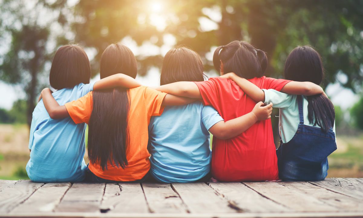 fotografia dzieci siedzących tyłem do fotografa 