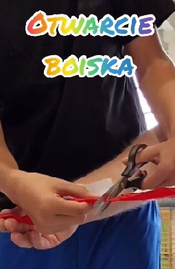 Zdjęcie przedstawia przecięcie wstęgi w czasie uroczystości otwarcia wyremontowanego boiska sportowego.