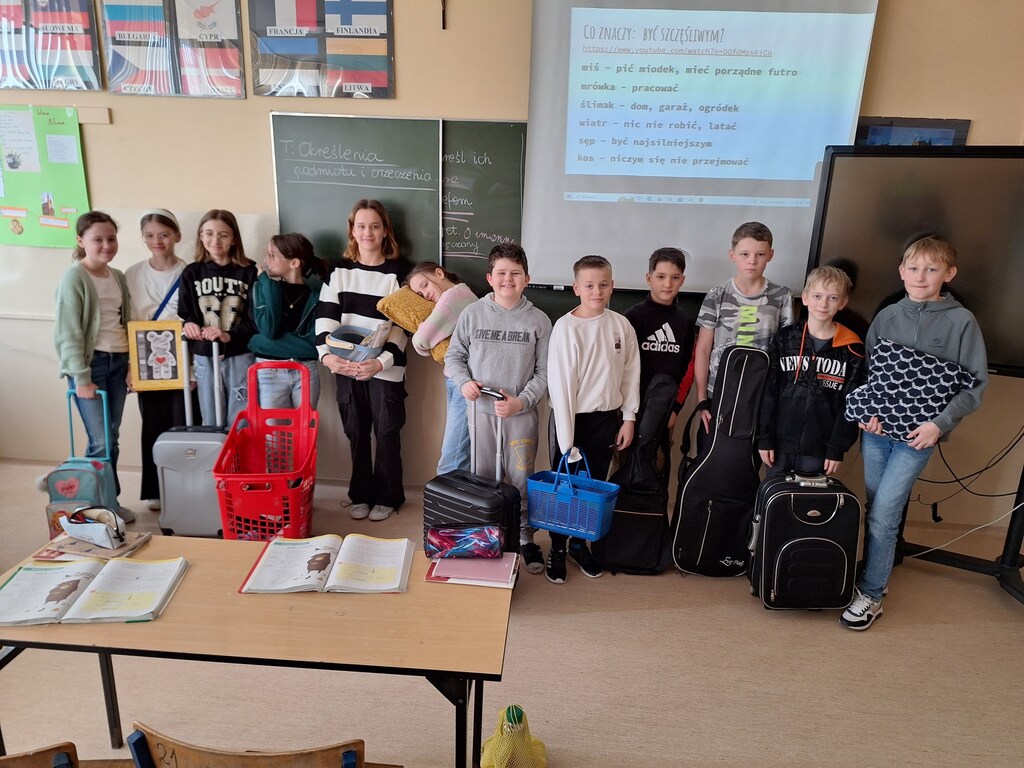 Kadr przedstawia uczniów trzymających różne przedmioty na podręczniki zamiast plecaka