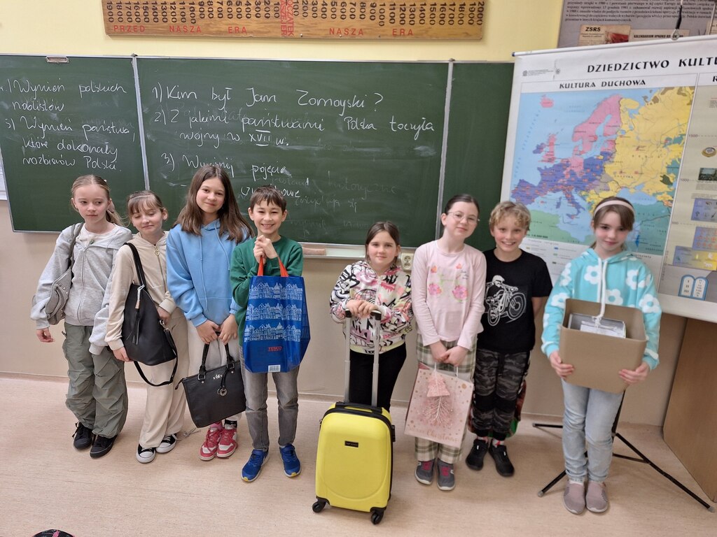 Kadr przedstawia uczniów trzymających różne przedmioty na podręczniki zamiast plecaka