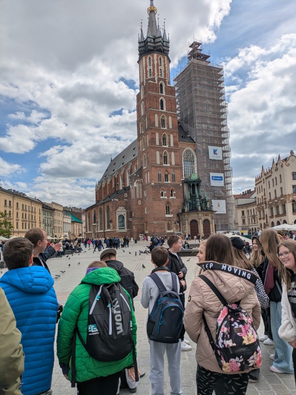 Zdjęcie przedstawia grupę uczniów na tle Kościoła Mariackiego w Krakowie