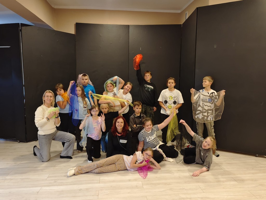 Profilaktyczne warsztaty dramowo - teatralne w ATiSW w Rybniku. Zabawy z chustami. Pamiątkowe zdjęcie z prowadzącą i wychowawcą klasy.