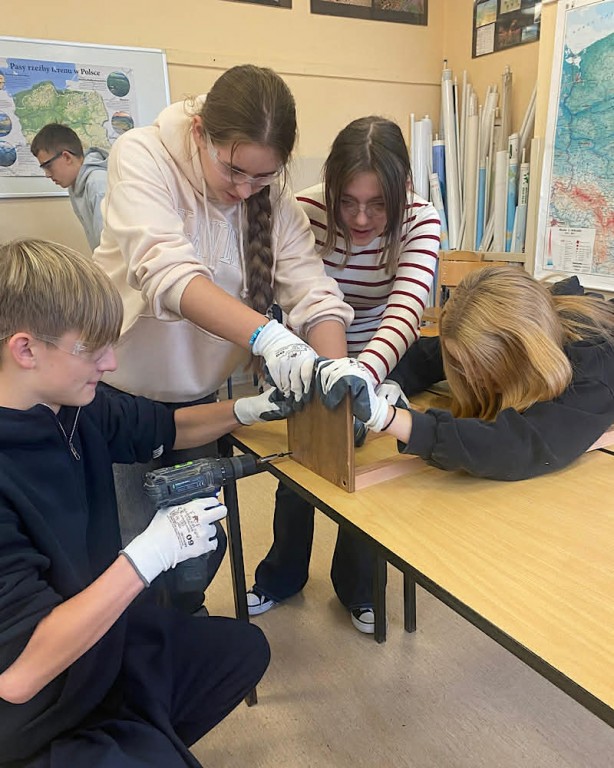 Zdjęcie przedstawia uczniów klasy 7b podczas robienia karmników-grupa 1