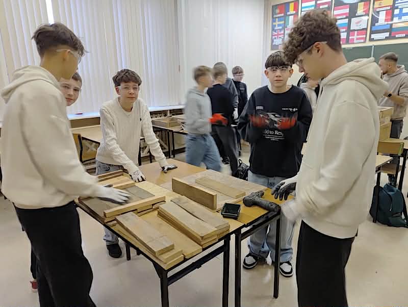 Zdjęcie przedstawia uczniów klasy 7d podczas robienia budek dla jeży z recyklingu-grupa 2