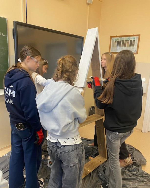 Zdjęcie przedstawia uczniów klasy 6b w trakcie malowania choinek świątecznych-grupa 1