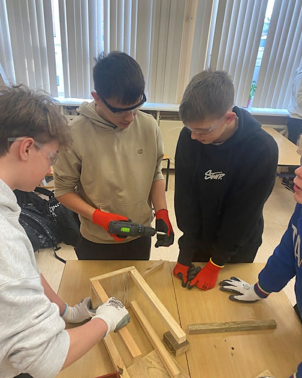 Zdjęcie przedstawia uczniów klasy 8b podczas robienia lampionów świątecznych-grupa 1