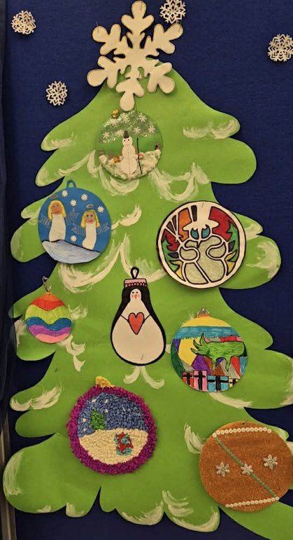 Zdjęcie przedstawia dużą zieloną , ośnieżoną choinkę na której znajdują się ozdoby choinkowe - kolorowe bombki świąteczne.