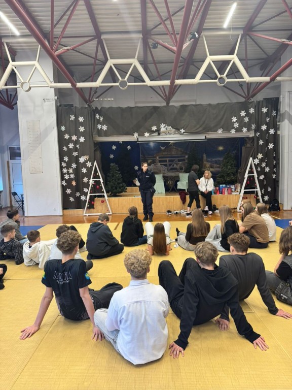 Policjantka stoi w auli szkolnej