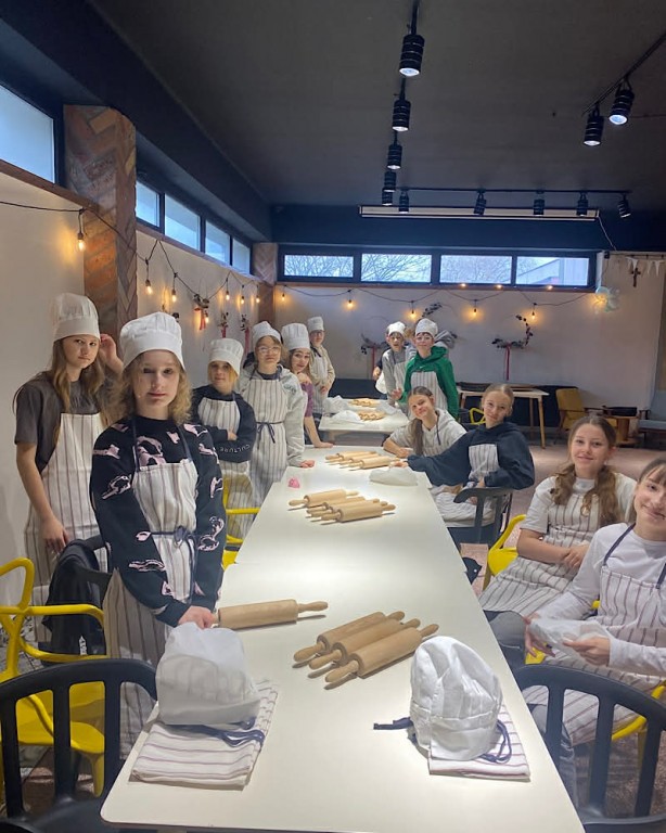 Zdjęcie przedstawia uczniów klasy 6b przed przystąpieniem do robienia ciasta na pizzę.