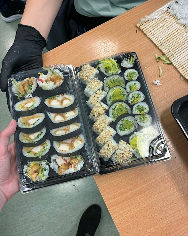 Zdjęcie przedstawia gotowe sushi z różnymi dodatkami.