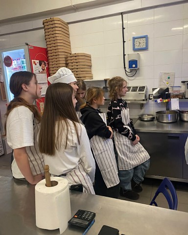 Zdjęcie przedstawia uczniów klasy 6b podczas oglądania wypiekania pizzy.