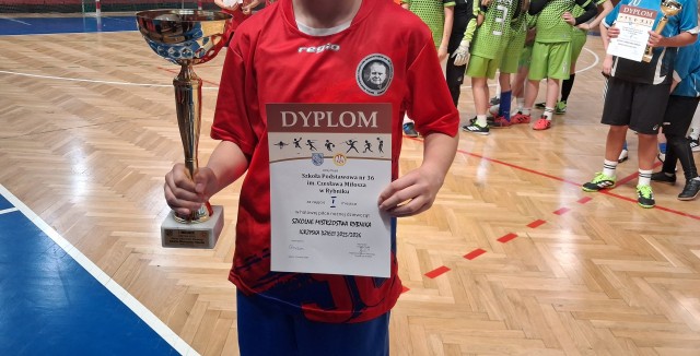 Zawodniczka zwycięskiej drużyny z pucharem i dyplomem.