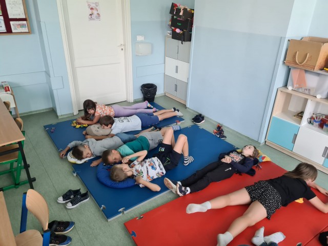 Tydzień uważności, wdzięczności i relaksacji w kl. 2c. Zdjęcie przedstawia uczniów podczas zajęć relaksacji.