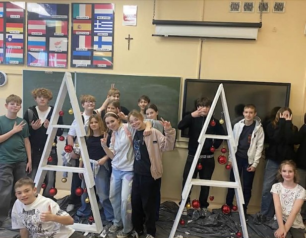 Zdjęcie przedstawia uczniów klasy 6b  prezentujących zrobione choinki podczas świątecznych warsztatów .