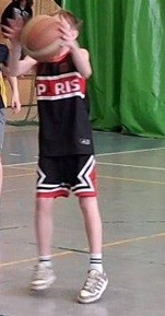 Uczeń przymierza się do wykonania rzutu do kosza.