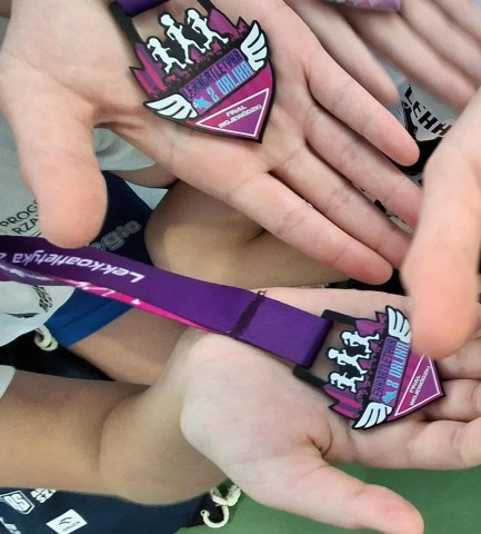 Ręce dzieci trzymające medale za udział w zawodach sportowych - "Lekkoatletyka z Orlika"